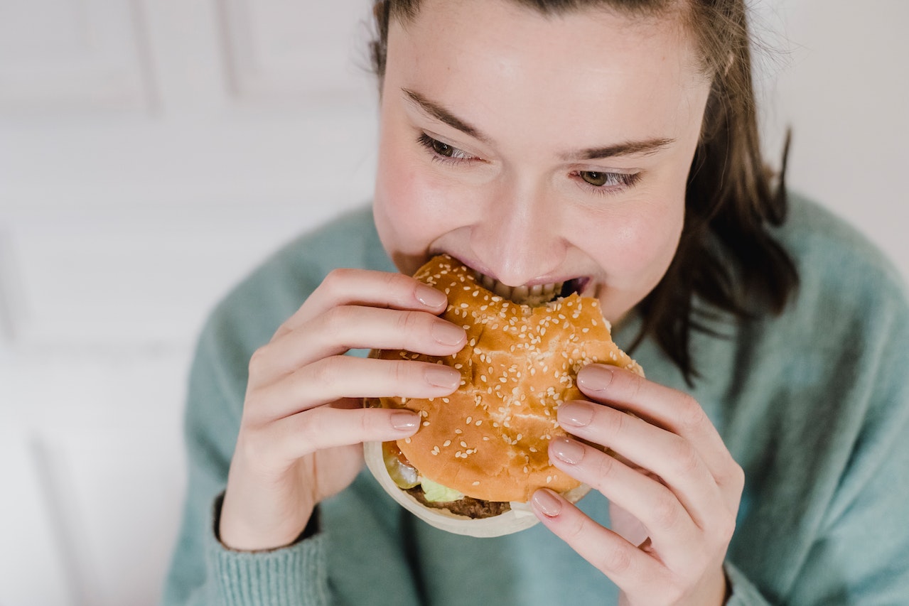 best-cure-for-gas-what-is-it-best-cure-for-gas-and-more-flatulence-gasiness-gassy-stomach-woman-eating-hamburger-in-a-hurry-swallowing-air-uniqsource-com